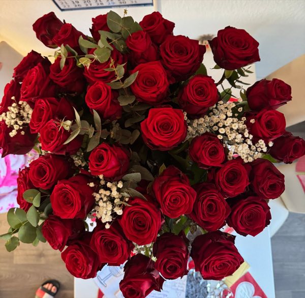 Großer Strauß roter Rosen mit Schleierkraut