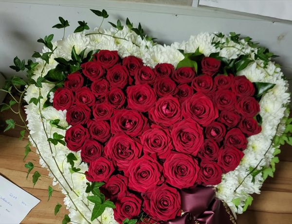 Trauerherz aus roten Rosen mit weißem Chrysanthemenrand