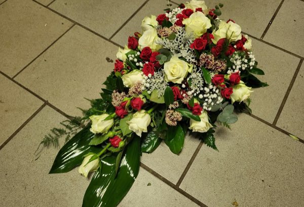 Trauergesteck in Rot und Weiß mit Rosen und Schleierkraut